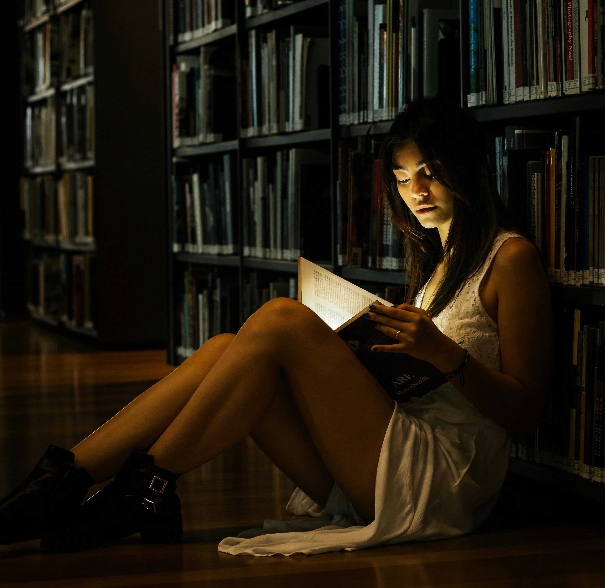 Femme qui lit dans bibliothèque